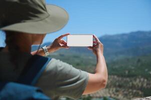 Traveler Taking a Photo of Mountain Scenery With Smartphone