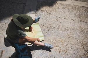 Traveler Exploring a Medieval Spanish Village Using a Map in Sunlit Streets photo