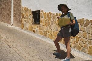 Adventurous Tourist Exploring a Scenic Historic Village with Spanish Architecture photo
