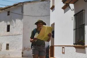 Tourist Exploring Charming Spanish Village with Map in Hand photo