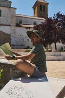 Traveler Exploring a Scenic Medieval Village With Map and Sun Hat photo