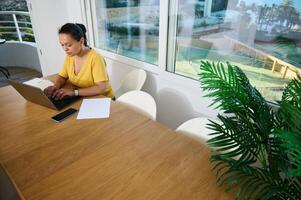 Focused Entrepreneur Working Remotely From a Modern Bright Home Office With Internet Access photo