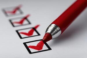 Red pen marking checkboxes on a white paper list in an office setting photo