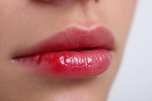 Makeup application highlights glossy lips in a beauty setting during daytime hours photo