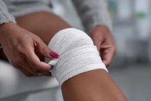 Patient receives bandaging on a knee at a medical facility during a routine check-up photo