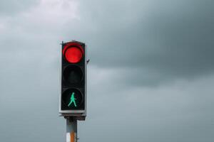 Traffic light displaying red and green signals with cloudy sky in the background photo