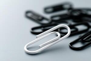 Papers organized with silver and black paper clips on a smooth surface in a neat arrangement photo