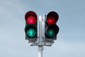 Traffic light indicating stop and go in a clear sky during midday in an urban setting photo