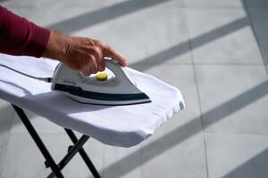 Ironing clothes in a bright room with sunlight streaming through the windows photo