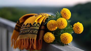 Bright yellow marigolds adorned with a traditional scarf on a balcony overlooking a lush landscape photo
