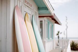 Colorful surfboards displayed outside a beach cottage by the ocean on a sunny day photo
