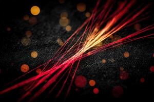 Vibrant strands of red and orange threads create an artistic display on dark fabric photo