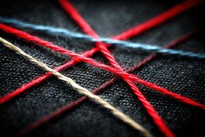 Colorful threads crossing on dark fabric create an intricate pattern of texture and craft photo