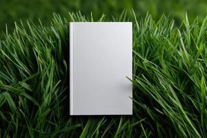 Blank notebook resting on lush green grass in a serene outdoor setting photo