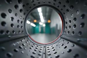 Looking through a circular opening in a modern washing machine at a laundromat photo