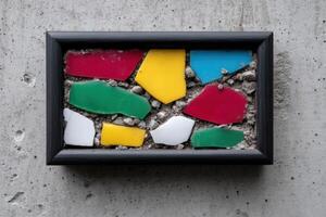Modern mosaic art piece created with phone tiles displayed on a gray concrete wall photo