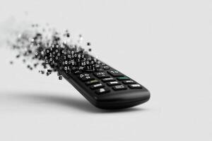 Remote control dissolving into binary code creates a visual representation of digital transformation photo
