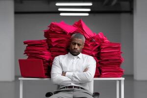 Man in business attire overwhelmed by paperwork at office desk during work hours photo