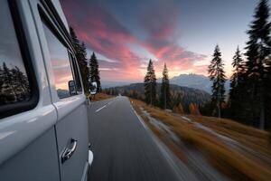 Couple enjoys sunset road trip in vintage RV through mountainous landscape photo