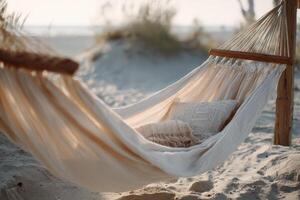 Chic beige hammock swaying gently on sandy beach during sunset photo