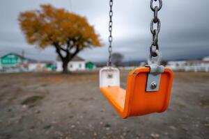 Swing sways gently in a quiet playground during an overcast afternoon photo