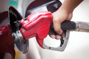 Fueling a vehicle with a gallon of gas at a local station in daylight hours photo