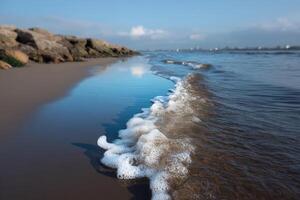 Waves form intricate patterns of foam along a tranquil shoreline at midday photo