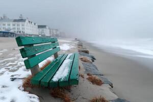 Park bench immersed in sand on a quiet summer beach during a foggy day photo