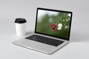 Laptop with AI interface displayed on a white table next to a coffee cup photo