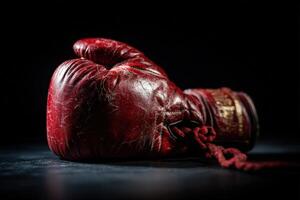 Boxing glove resting against a dark background with subtle texture and detail photo