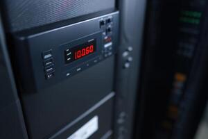 Rack-mounted UPS unit displaying LCD readout in a server room setup photo