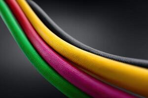 Curved patch cords in vibrant colors against a dark background photo