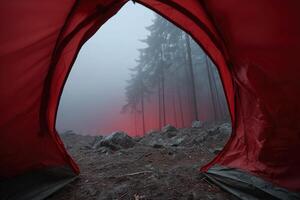 Foggy morning view from a camping tent amidst forest trees and rocks photo