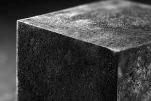 Metal cube with velvet sharp edges displayed on a dark surface photo