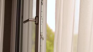 A sunlit room features an open window allowing fresh air to flow inside, while soft curtains gently move with the breeze, creating a peaceful atmosphere video