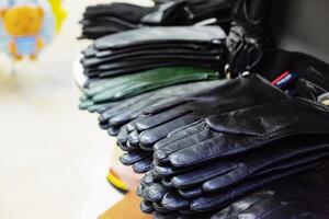 Multiple pairs of black leather gloves on a store shelf. Seasonal rest. photo