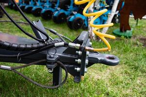 Close-up of agricultural machinery hitch on grass background. photo