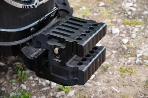 Close-up of a tractor weight on rugged terrain. photo