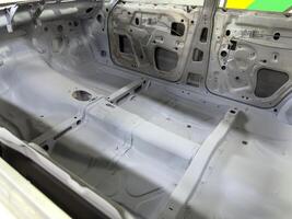 Restored car interior with visible tunnel reinforcement and detailed floorpan shaping, highlighting structural preparation for performance upgrades and racing modifications photo