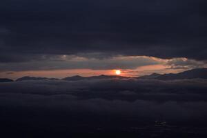 A view of the sun setting over the mountains photo