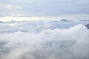A plane flying over a city with clouds photo