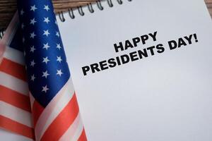 Concept of happy presidents day write on book and american flag isolated on Wooden Table. photo