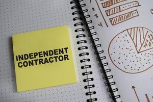 Concept of Independent contractor write on book and chart isolated on Wooden Table. photo