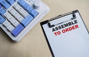 Concept of Assemble to order write on clipboard isolated on Wooden Table. photo