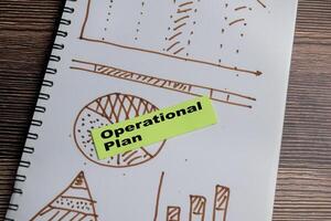 Concept of Operational plan and charts write on sticky notes isolated on Wooden Table. photo