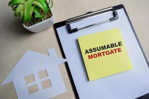 Concept of Assumable mortgage write on sticky notes isolated on Wooden Table. photo