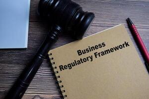 Concept of Business regulatory framework write on book isolated on Wooden Table. photo