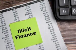 Concept of Illicit Finance write on sticky notes isolated on Wooden Table. photo