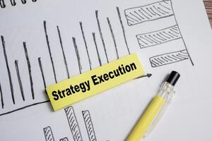 Concept of strategy execution and charts write on sticky notes isolated on Wooden Table. photo