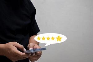 customer man hand pressing on smartphone screen with gold five star rating feedback icon and giving best score point to review the service, photo